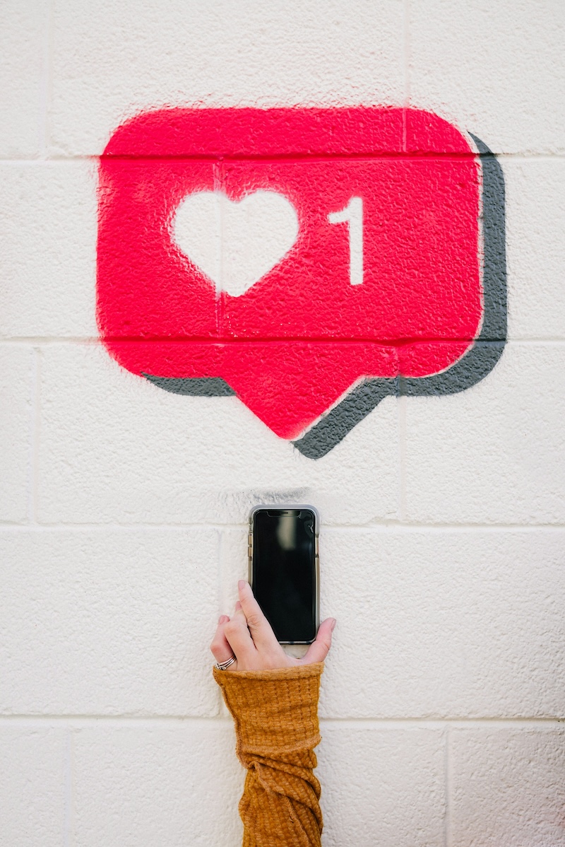 Image of a cellphone held up to a wall spray painted with a heart
Photo by Karsten Winegeart on Unsplash